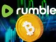 Logo da Rumble ao lado de uma moeda de Bitcoin dourada com gráficos de mercado em fundo verde e azul.