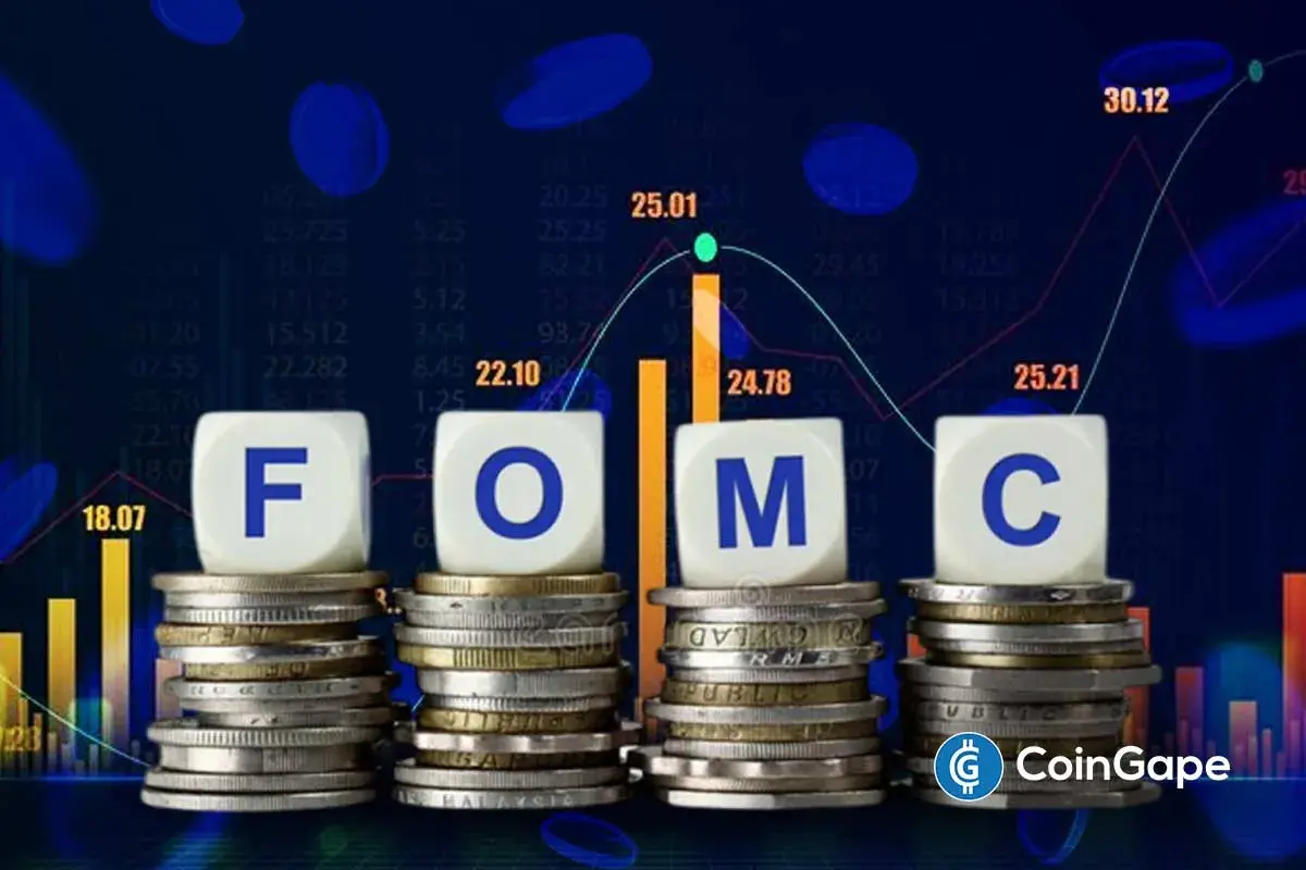 Três dados brancos com as letras F, O, M e C sobre pilhas de moedas, com gráficos financeiros ao fundo, ilustrando o FOMC. Imagem: CoinGape.