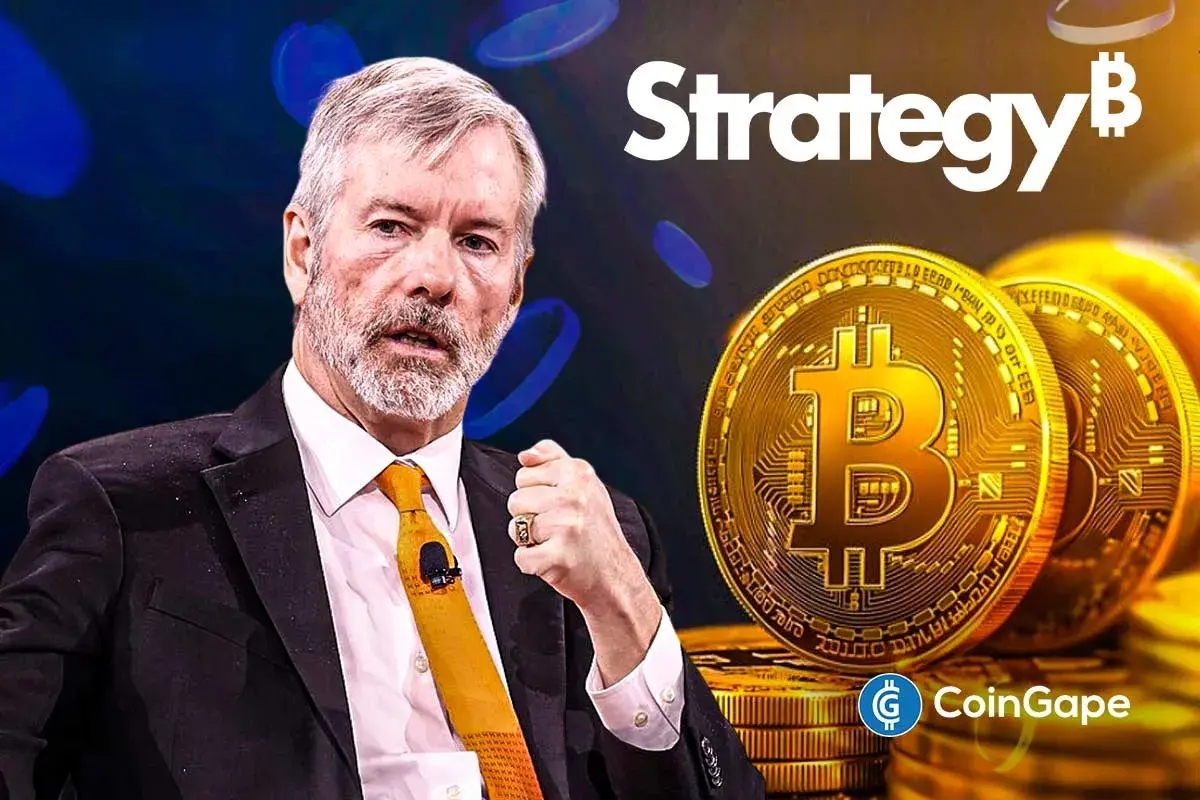 Michael Saylor, fundador da Strategy, ao lado de moedas de bitcoin douradas e o logotipo da empresa ao fundo.