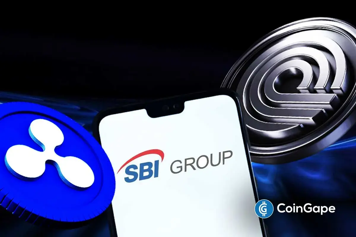 Logo da SBI Group em smartphone entre os símbolos da Ripple e da Ondo Finance.